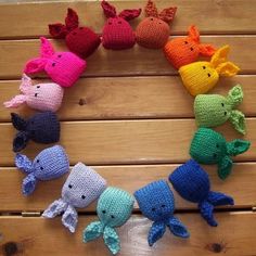 there are many crocheted animals arranged in the shape of a circle on top of a wooden table