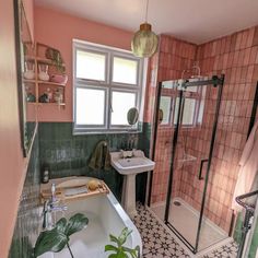 a bathroom with pink and green tiles on the walls, white fixtures and a bathtub