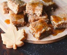 several pieces of cake sitting on top of a wooden cutting board next to a maple leaf