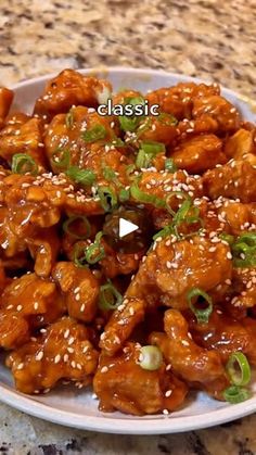 a white plate topped with chicken covered in sesame seeds