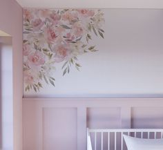 a baby's room with pink flowers painted on the wall and white crib