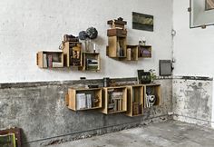 two wooden shelves with books on them against a wall