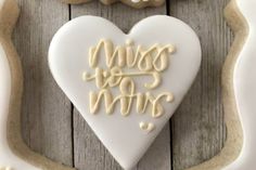 a cookie shaped like a heart with the words miss you written in white frosting