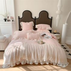 a bed with pink comforters and pillows in a bedroom