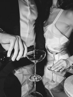 a man and woman sitting at a table with wine glasses