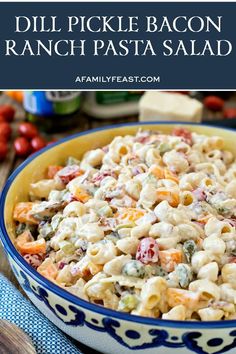 a bowl filled with pasta and vegetables on top of a blue table cloth next to other food