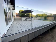 a deck with an umbrella on it and some chairs in the backround area