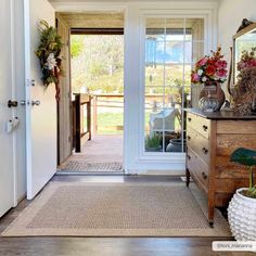 an entry way with flowers and plants on the table