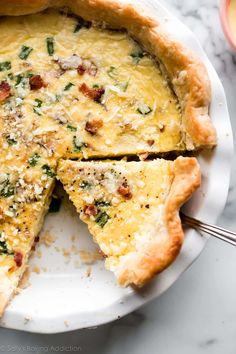 a quiche on a plate with one slice missing