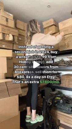 a woman standing on top of a chair in a room filled with boxes