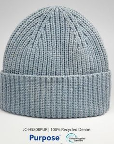 a light blue knitted beanie hat with the words purpose written on it in white