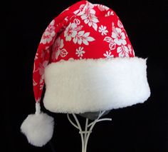 If you are celebrating a tropical Christmas this year you may need a special hat.  This novelty Santa hat is made up in a Christmas red and white Hawaiian traditional hibiscus print cotton fabric. Hat is decorated with a snowy white soft faux Sherpa fur fabric turn up brim and hat is fully lined with a white cotton fabric. Put Santa in a tropical island mode for that balmy warm holiday season.   The sizing on this hat is generous and will fit most adult head sizes.   The styling is a slouch cone, traditional Santa style. There is a snowy white faux fur pompom stitched on the top. Opening measurement is 24-25" circumference, tapering in cone style and the length of the hat is 19".  Please check the measurements for circumference of head sizing.  Custom orders for smaller sizes or quantity a White Christmas Hat As Gift, Adjustable Red Hats For Holiday, Adjustable Red Hat For Holiday, White Christmas Cap, White Christmas Holiday Hat, Hawaii Christmas Hat, Cow Santa Hat, Adjustable Red Christmas Hat, Red Adjustable Christmas Hat