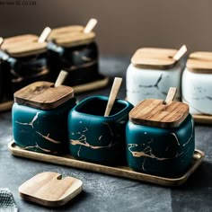 teal and gold canisters on a tray with wooden spoons in them