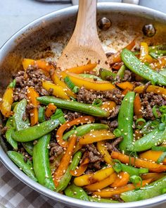 stir fry with meat, peppers and sesame seeds in a skillet on the stove