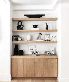 a wooden shelf filled with vases and other items on top of it's sides