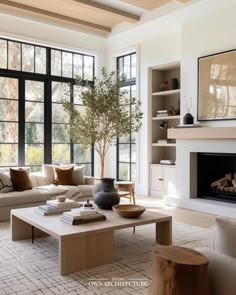 a living room filled with furniture and a fire place in front of a large window