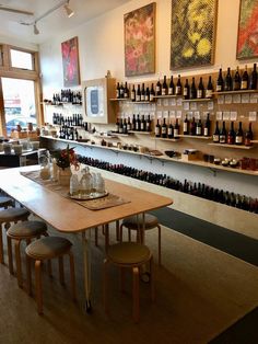 an empty restaurant with wine bottles on the wall