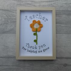 a white frame with a yellow and orange flower in it that says teacher thank you for helping us grow