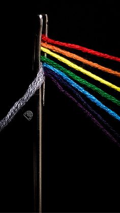 there is a multicolored string on the top of a pole with a black background