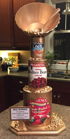 a stack of canned food on top of a kitchen counter next to a lamp shade