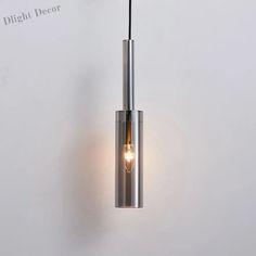 a light that is hanging from the ceiling in front of a white wall with writing on it