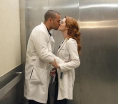 two people in white lab coats kissing each other