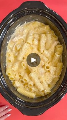 a bowl filled with macaroni and cheese on top of a pink table