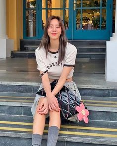 a woman sitting on the steps with her legs crossed