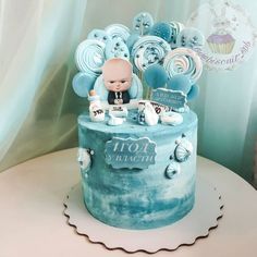 a blue and white cake with balloons on top