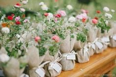 several bags filled with flowers sitting on top of a wooden table next to each other