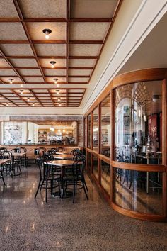 an empty restaurant with wooden tables and chairs