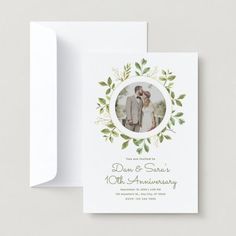 a wedding card with an image of the bride and groom in green leaves on it