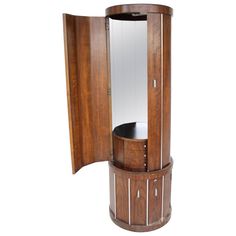 a wooden corner cabinet with mirror on the top and door open to reveal it's own storage compartment