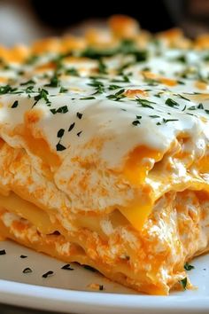 a white plate topped with layered lasagna covered in cheese