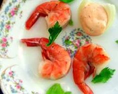 some shrimp is on a white plate with green garnish