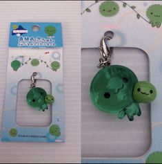 two keychains with green cartoon characters on them sitting next to each other in front of a package