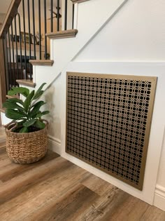 a potted plant sitting on the floor next to a stair case in a house