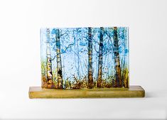 a painting of trees on a wooden stand