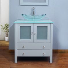 a bathroom vanity with a glass sink and mirror on the wall next to a wooden floor