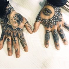 two hands that have tattoos on them and one has an all seeing eye in the middle