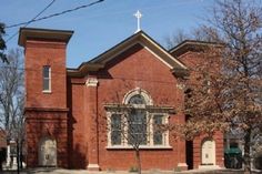 an old red brick church with a cross on top