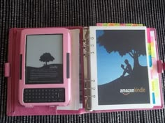 a pink kindle case with an image of a tree on it and a book