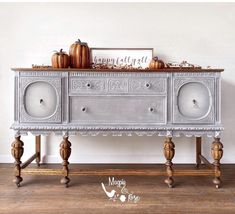 an old dresser is decorated with pumpkins and other decorations for fall or halloween time