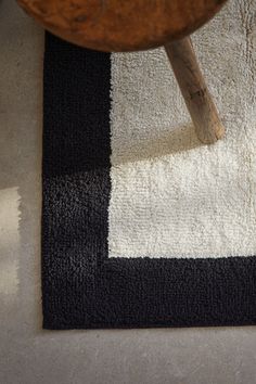 a black and white rug with a wooden chair in the background