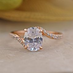 an oval shaped white diamond ring with rose gold band