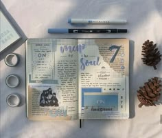 an open journal with pine cones and scissors