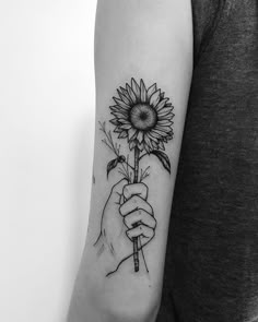 a woman's arm with a sunflower tattoo on it