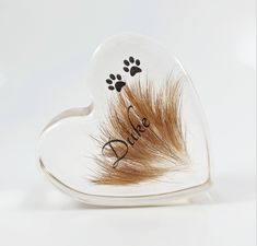 a dog paw and heart shaped glass dish with the word dad written in black on it