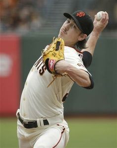 a baseball player pitching a ball on top of a field