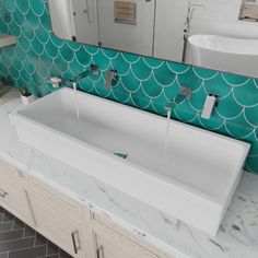 a white sink sitting under a bathroom mirror next to a bath room with two sinks